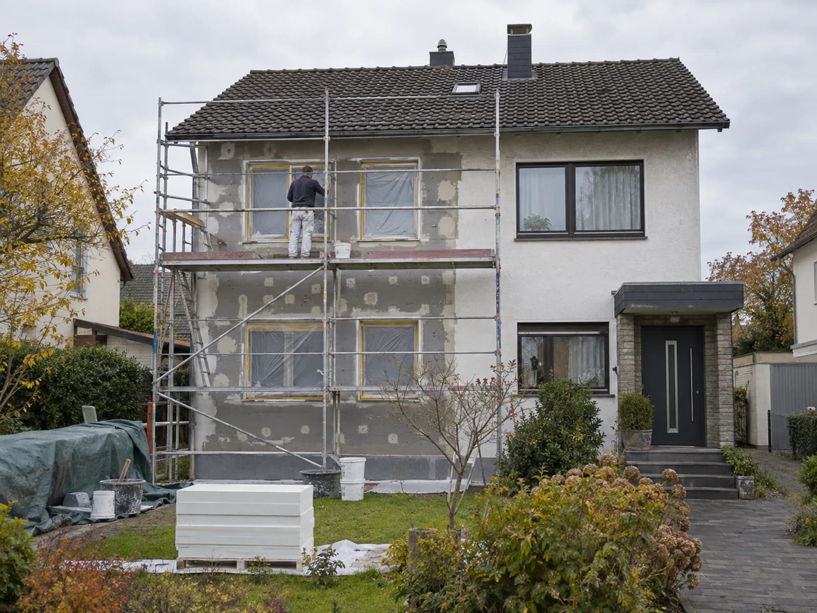 Einfamilienhaus während einer umfassenden Sanierung mit Gerüst und laufenden Arbeiten
