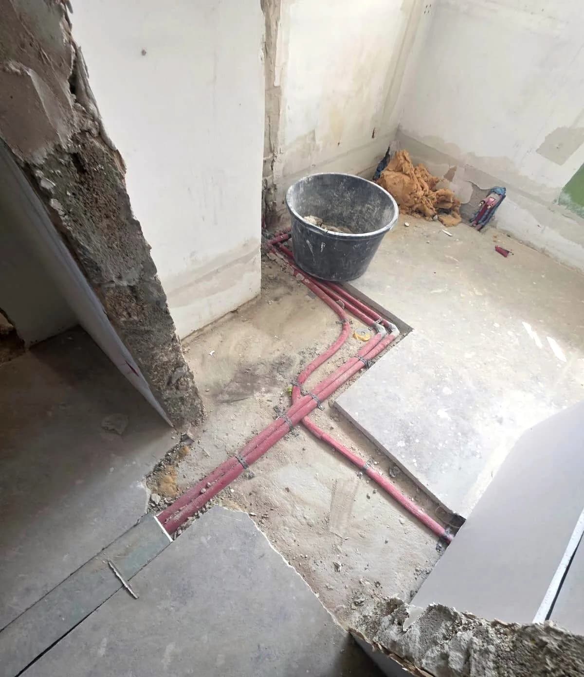 Verlegte Leitungen im Fußbodenaufbau einer Bestandswohnung, bevor die Oberflächen geschlossen werden