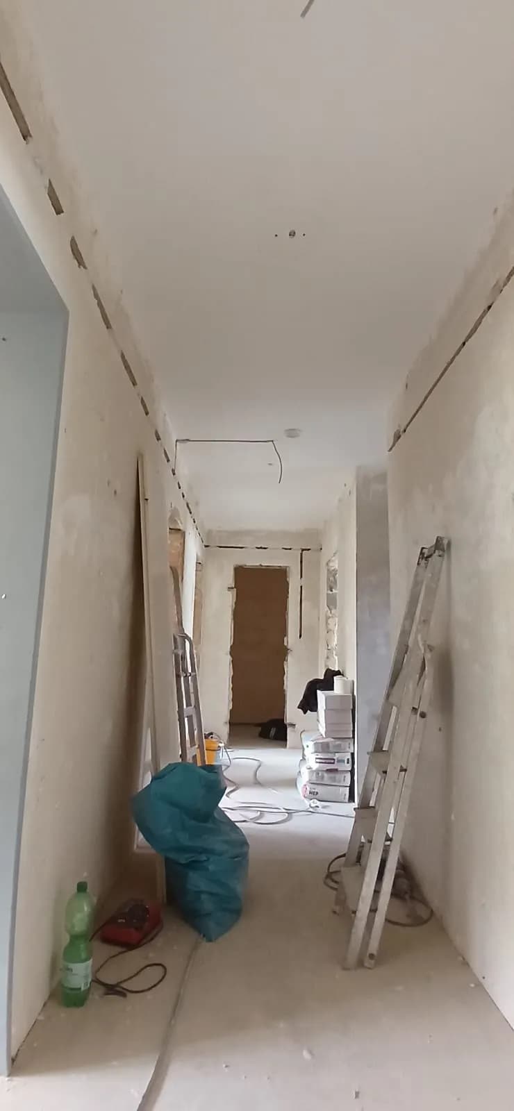 Flur im Ausbau mit geführten Leitungswegen entlang von Wand und Decke