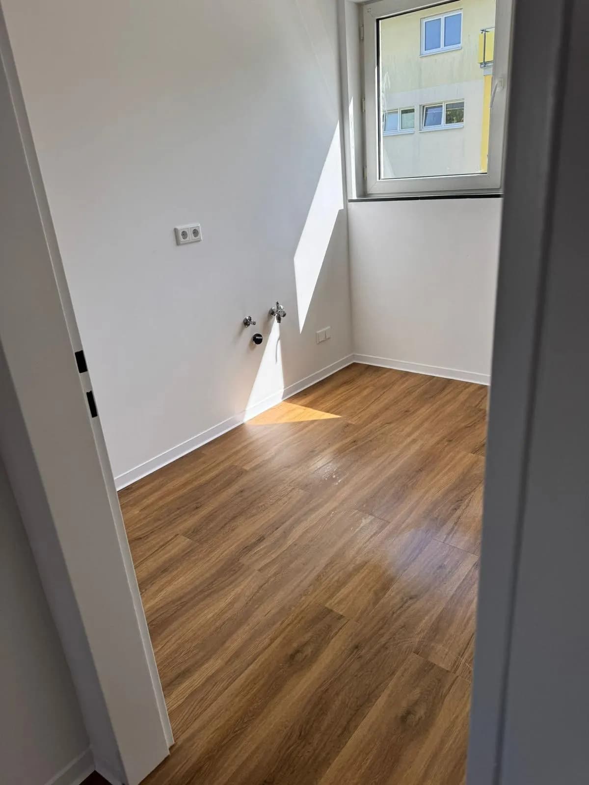 Raum mit fertiggestellten Wänden, Anschlüssen und neuem Boden