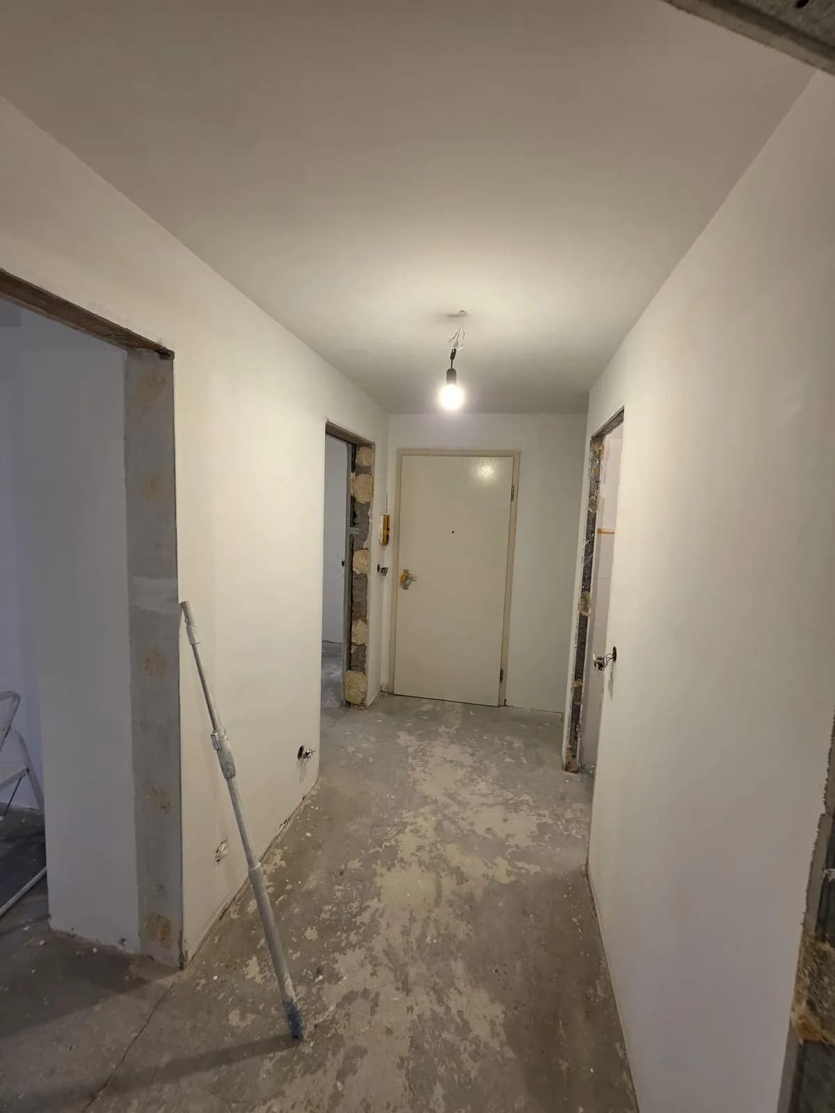 Flur einer Wohnung vor den Sanierungsarbeiten mit freigelegtem Boden
