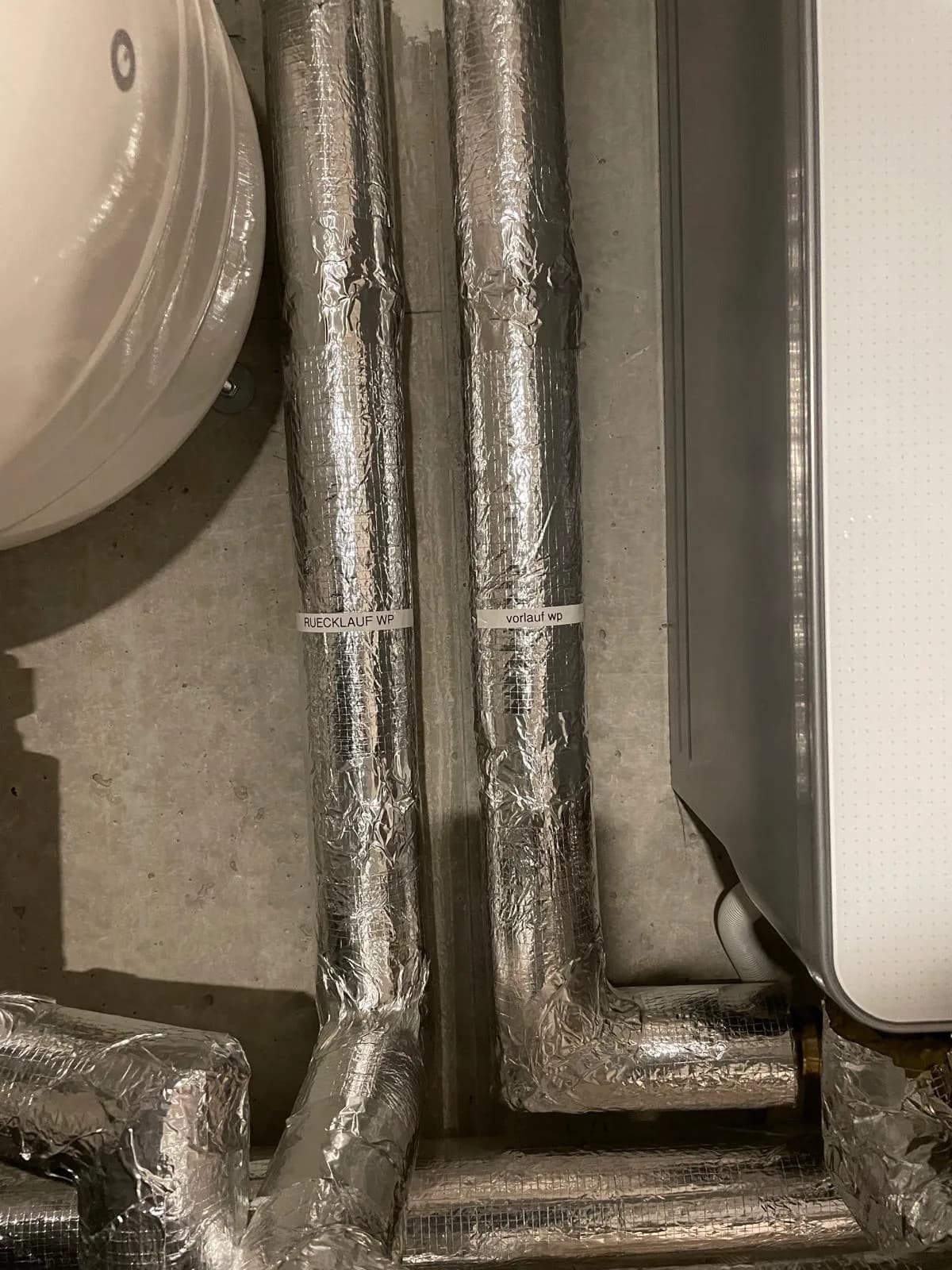 Gedämmter Vorlauf und Rücklauf der Wärmepumpe im Technikraum