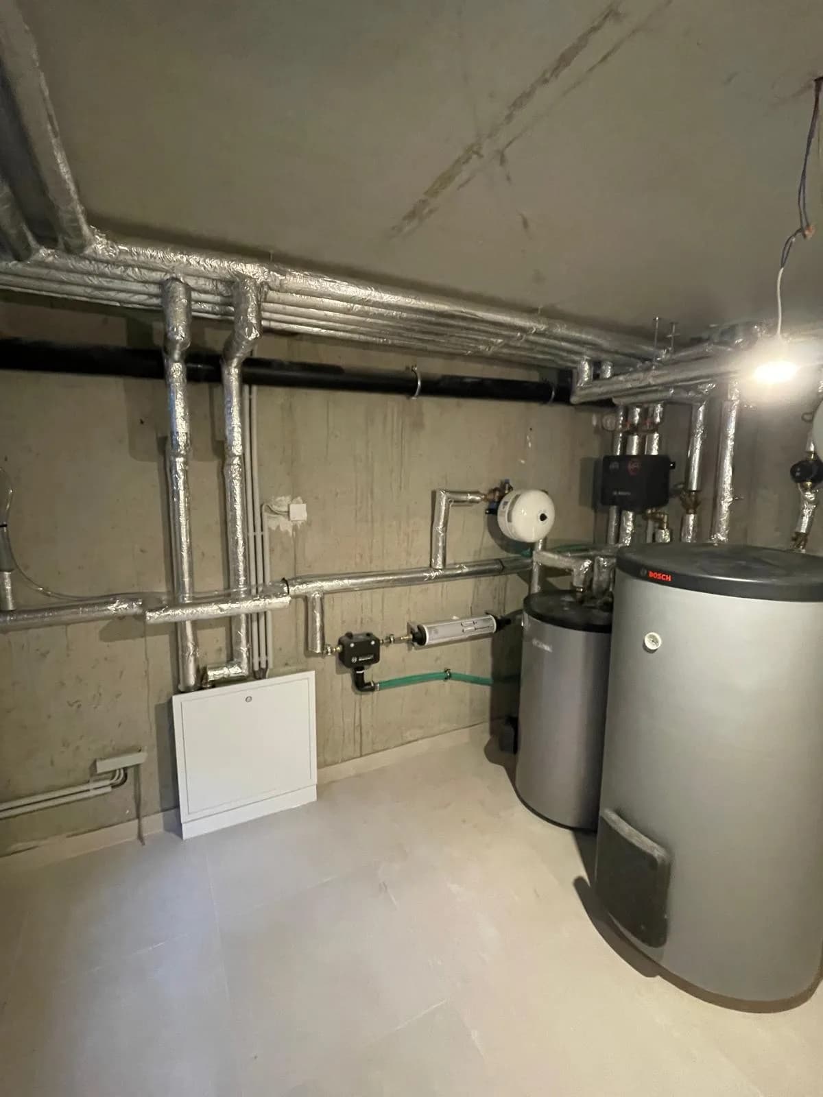 Gedämmte Rohrleitungen und technische Installation im Heizungsraum