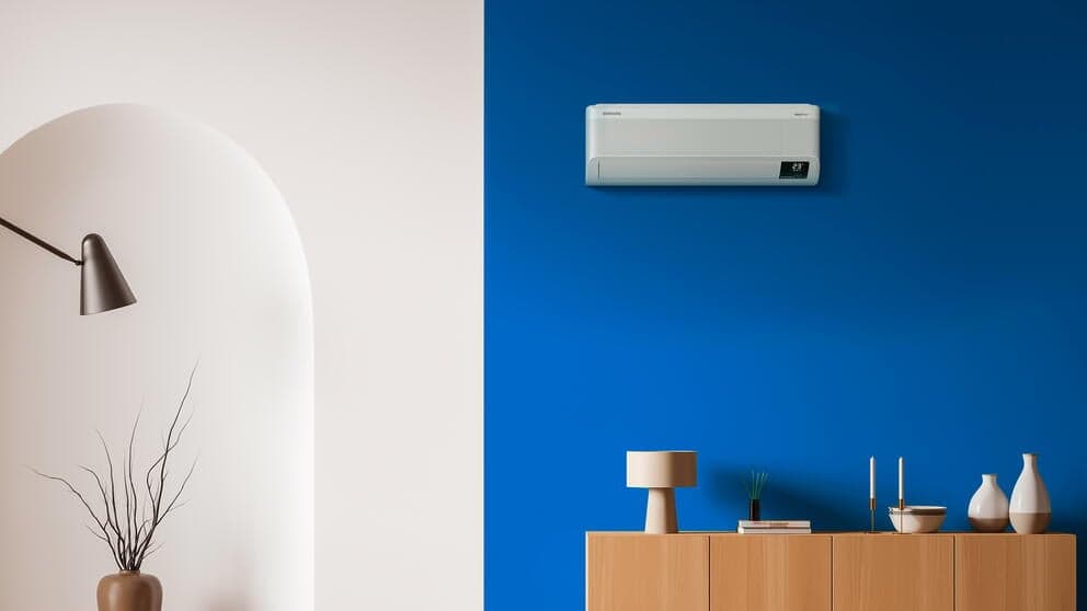 Split-Klimagerät an einer blauen Wohnzimmerwand über einem Sideboard
